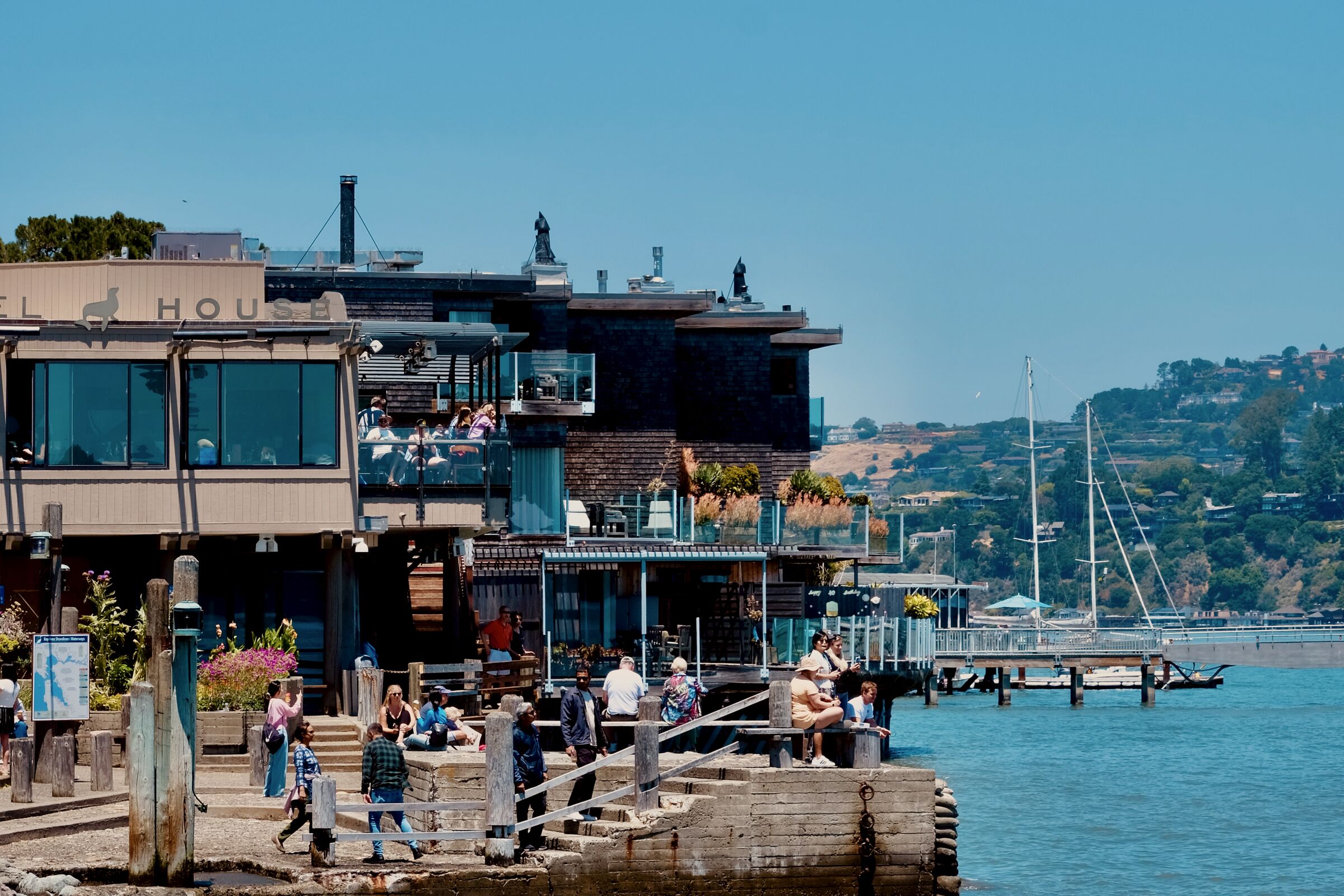 Sausalito waterfront with restaurants stacked along the pier and hills behind